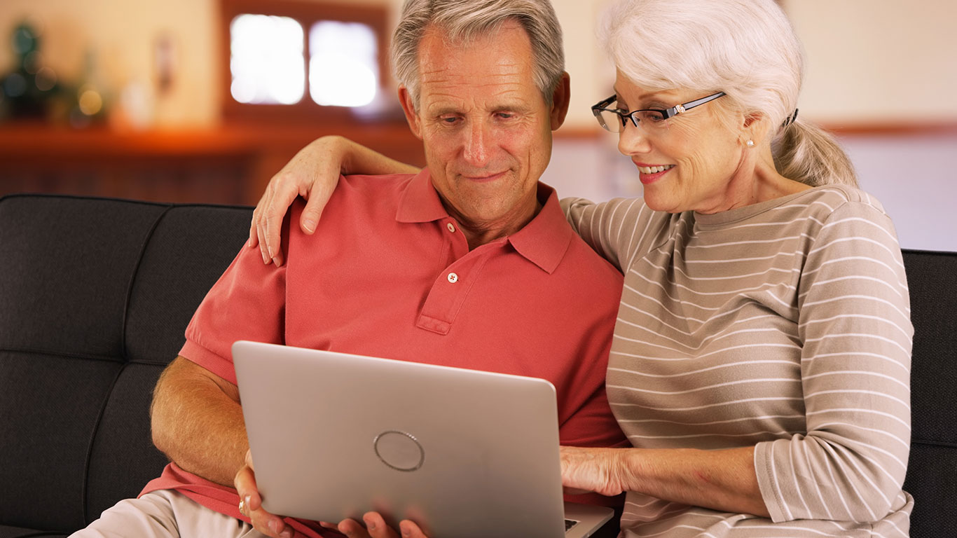 Older-Couple-Looking-at-Laptop-on-Couch