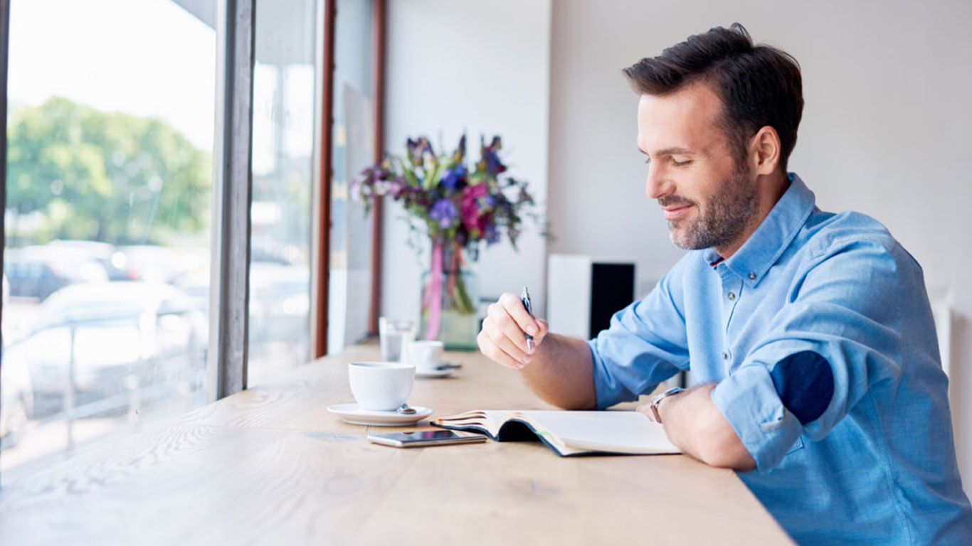 Man-Sitting-at-Desk-Smiling