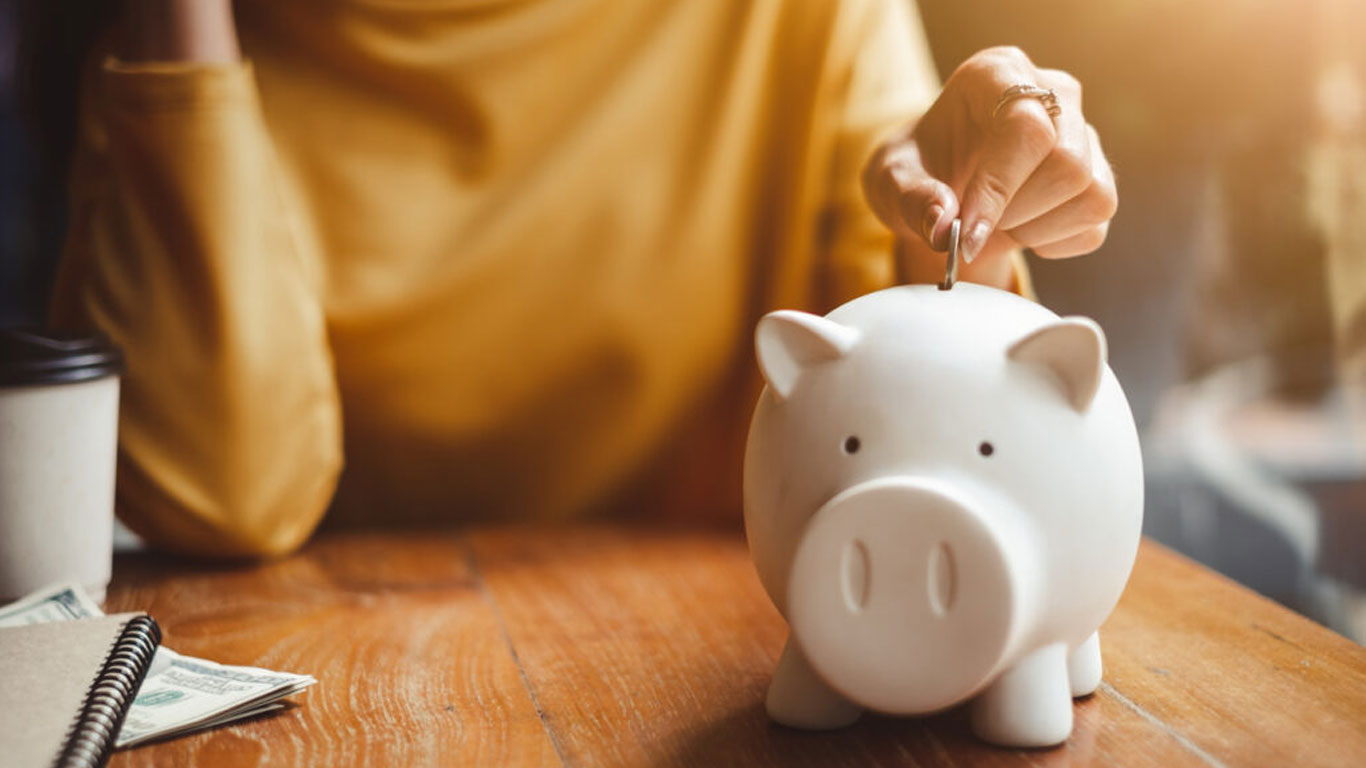 Woman-Putting-Coin-in-Piggy-Bank